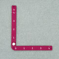 Swatch Gauge in Plum measuring a knitted swatch in the 4 inch window