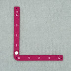 Swatch Gauge in Plum measuring a knitted swatch in the 4 inch window